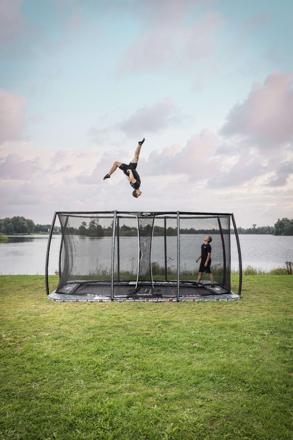 BERG FlatGround Pro Bouncer trampoline with a safety net, set level with the lawn in a garden